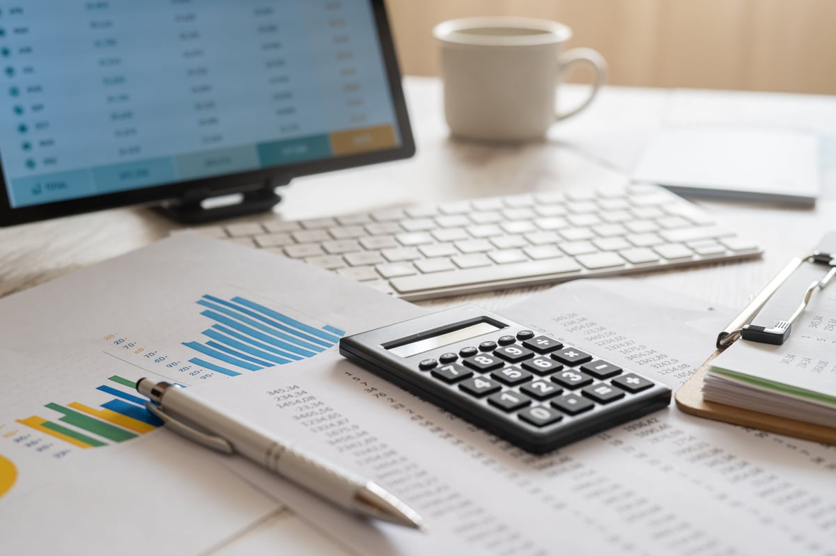 Gerente financiero de una PyME en crecimiento revisando reportes contables y calculadora para regularizar su situación ante el SAT en Cancún